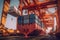 Loading a container ship at cargo berth of the seaport using port cranes. Containers are stacked and secured on board