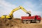 Loading of earth soil into the body of a cargo dump truck