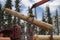 Loading logs onto a logging truck. Portable crane on a logging truck