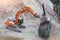 Loading metal reinforcement at a destroyed building with an excavator with a magnet