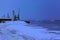 Loading pier with cranes on river at night in winter