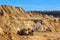 Loading sand with a wheeled front loader with a large bucket into a heavy dump truck