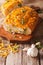 loaf of bread baked with cheddar cheese, garlic and herbs closeup. vertical