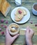 A loaf of bread and a sandwich a piece of loaf with nut paste a Cup and children`s hands holding a jar with nut paste and berry