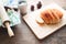 Loaf of bread on wood background with cup of coffee and bakery tools