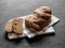 Loaf dark buckwheat bread on white textile napkin black table background. Fresh delicious homemade healthy bake. Bakery