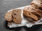 Loaf dark buckwheat bread on white textile napkin black table background. Fresh delicious homemade healthy bake. Bakery