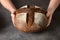 Loaf of freshly baked bread with hemp flour in hands.