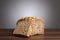 Loaf and slice of wholemeal bread on table