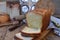 A loaf of white bread on a wooden background. Homemade Yeast Baking