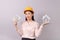 Loans for real estate concept, woman with yellow helmet holding banknote money in hand and white logo home icon in another hand