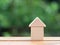 Loans real estate home concept. Wooden house miniature on wooden floor with blur green background.