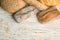 Loaves of different breads on white wooden background. Space for text