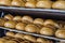 Loaves of fresh crusty bread on wooden multi-storey shelves