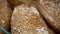 Loaves of rye farm bread lie on the wooden bakery shelf. Close-up shot. Shopping at the grocery store. Selling food