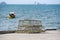 Lobster and crab pots stacked fishing net catching fishing boat on the bay ocean background