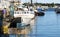 Lobster fishing boats docked in a canal with lobster traps pilled on the dock in Portland Maine