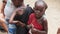 Local African Hungry Child Eats Paper on Street among People, Zanzibar, Africa