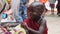 Local African Hungry Child Eats Paper on Street among People, Zanzibar, Africa