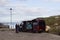 A local artist plies his trade with a potential customer at the Harbor in Ballintoy in Northern Ireland