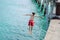 Local boy in red togs jumping of Tolaga Bay Wharf