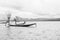 Local Burmese fisherman posing for photos with his net, balancing and steering boat with one foot.