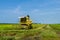 Local farmer uses machine to harvest rice on paddy field