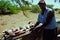 local fisherman cleaning the catch in the shade to get away from the tropical heat