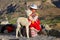 Local girl with baby llama sitting at Colca Canyon in Peru