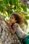 Local girl sitting on a palm tree in Lavena village, Taveuni Isl