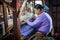 Local Intha woman weaving green lotus fabric on a loom at the local lotus cloth weaving workshop at Inle lake, Shan State, Myanmar