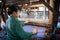 Local Intha woman weaving green lotus fabric on a loom at the local lotus cloth weaving workshop at Inle lake, Shan State, Myanmar