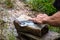 Local male farmer sharpening a knife with whetstone,