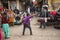 A local man dances while musicians play on the street