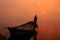 Local man moving boat on Yamuna River with a pole at sunrise, Ag