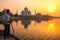 Local man steering boat on Yamuna river at sunset in front of Ta