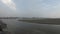 Local people walk on bridge across sangam to Kumbha Mela camp lights on other side