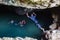 Local Polynesian teens playing and swimming in Veimumuni cave, while a girl jumping to the pool. Motion blur. Vavau, Tonga.