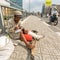 Local poor vietnamese man sitting on the street.