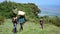 Local porters carrying gear and equipment hike towards the summit of Mount Meru in Arusha National Park in Tanzania