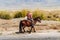 A local resident riding a horse in the autumn Chuy valley