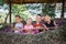 Local vacation. Group of friends playing with wooden rake on the hayloft at the farm