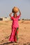 Local woman carrying jar with water on her head, Khichan village