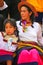 Local woman sitting with a girl during Festival of the Virgin de