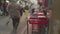 Local women in long dresses and kerchiefs and tourists walk in narrow streets of Tanger.