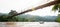 A local wooden boat passing the suspension wooden bridge at dusk