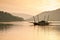 Local wooden ferry boat on peaceful lake at sunset