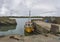 A local yellow Fishing Boat moored up next to the Harbour entrance of Fethard harbour.