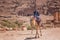 Local young man, jordanian riding a camel. Travel genre photography in Petra, Jordan