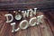 Lock down alphabet letters with alarm clock on wooden background